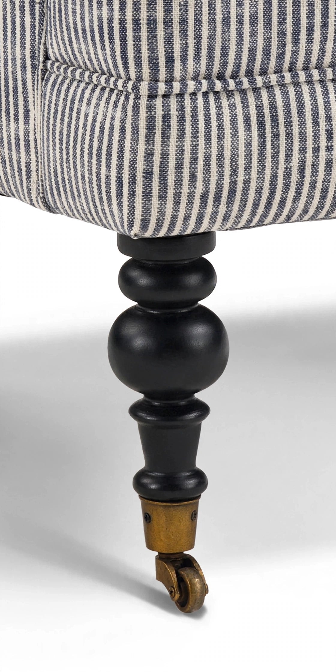Turned wood leg with brass caster detail